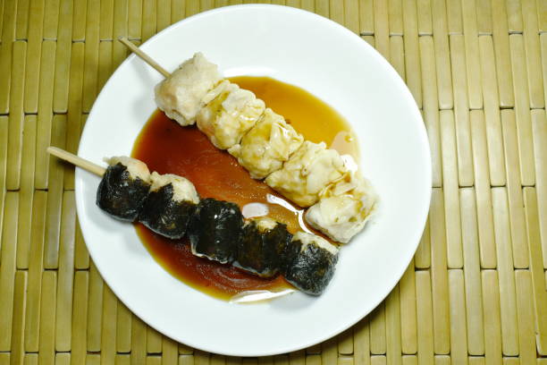 istock Chinese dumpling wrapped seaweed stabbing wooden stick dressing soy sauce 1128238992