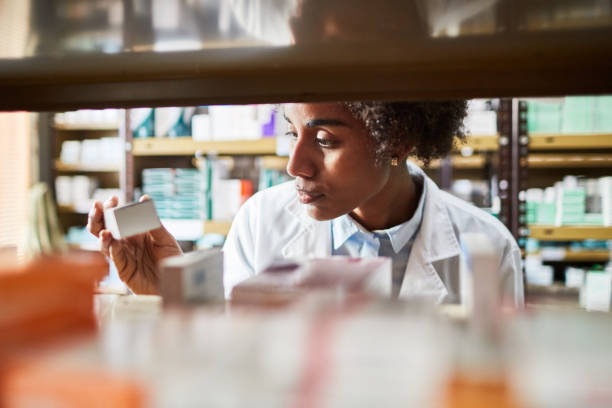 chimiste femelle africain recherchant les médicaments - fourniture médicale photos et images de collection