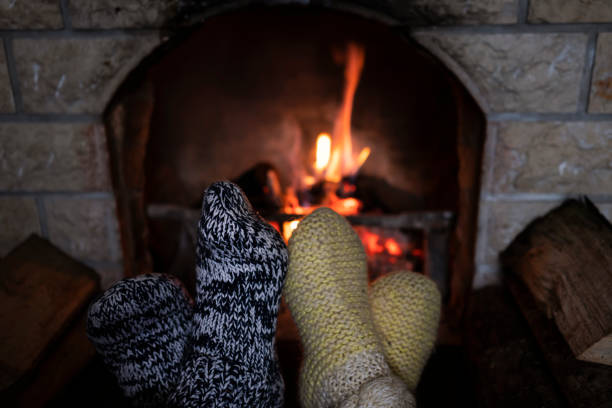 istock Foot in wool socks warming by the fireplace 1128239753