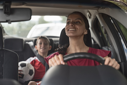 Feliz mamá de fútbol transporte de niños a la práctica de fútbol en su coche photo