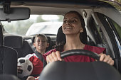 istock Happy soccer mom transporting kid to football practice in her car 1128240897