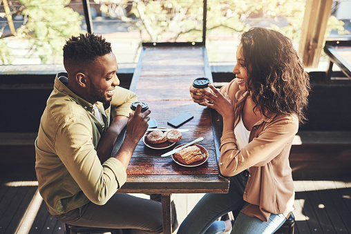 Shot of a young couple having pastries at a coffee shop