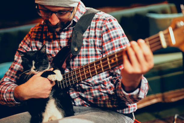 istock Caucasian musician with cap on head playing with cat. 1128241235