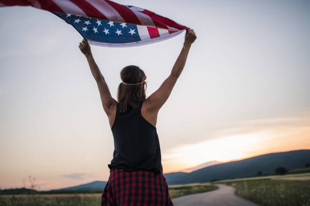istock Lady holding US flag on the street 1128243803