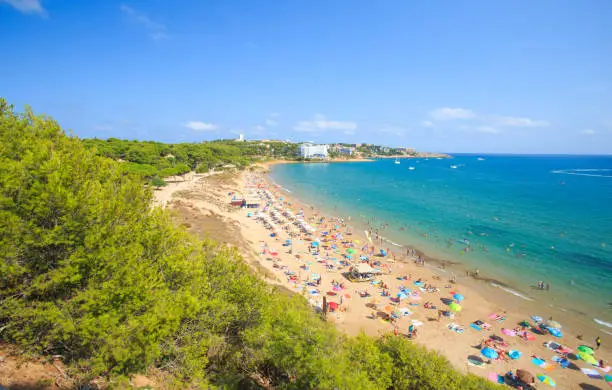 Salou, Spain. Beach with tourists in Salou resort. Costa dorada region in Spain. Summer tourist background.