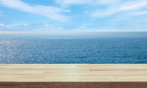 istock Empty table top with horizon and endless ocean blurred in the background. 1128247420