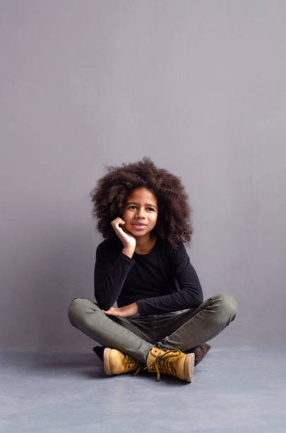istock A beautiful dark-skinned girl sits thoughtfully on the floor. 1128247559