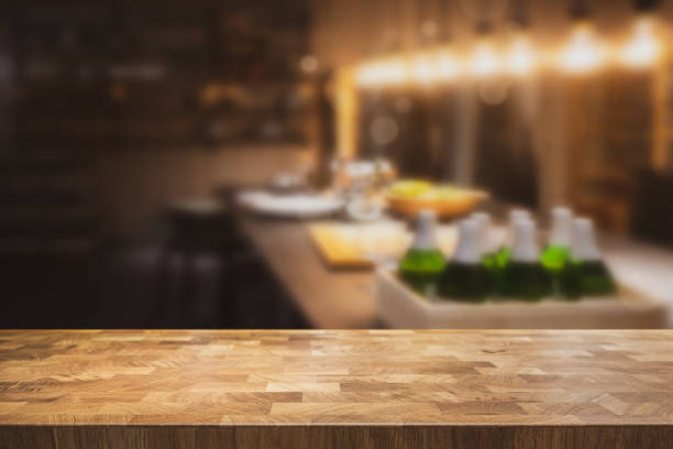 Empty table top with dark restaurant kitchen blurred in the background. stock photo
