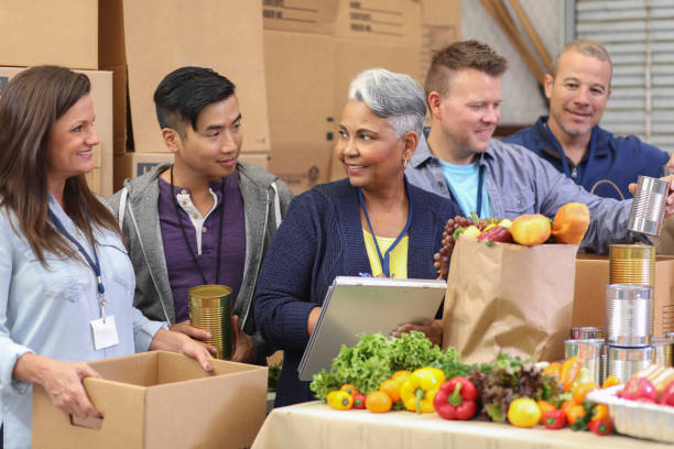 istock Multi-ethnic group of volunteers work at food bank. 1128250556