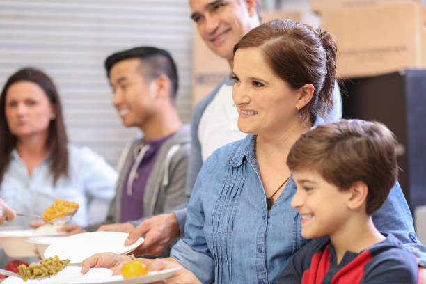 istock Multi-ethnic group of volunteers serves food at soup kitchen. 1128251243