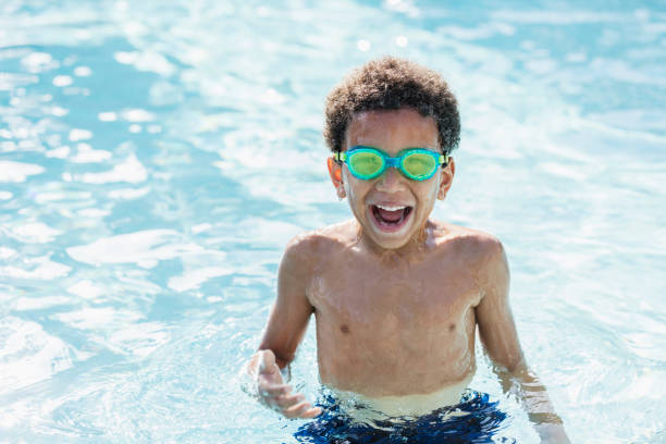 chico de raza mixta divirtiéndose en la piscina, riendo - child swimming pool swimming little boys fotografías e imágenes de stock