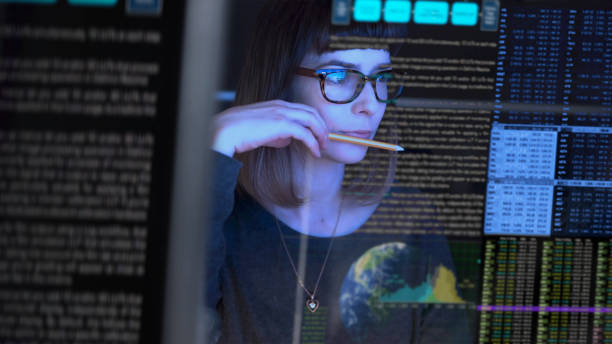 Close up watching Stock image of a beautiful young woman studying a see through computer screen & contemplating. data stock pictures, royalty-free photos & images
