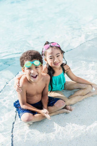 istock Two multi-ethnic children having fun in swimming pool 1128252226