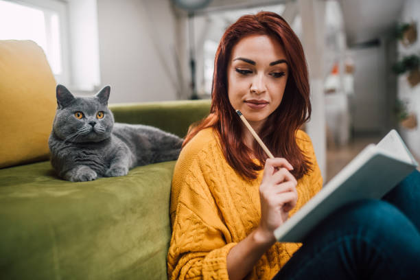 istock Cat looking at the girl studying 1128252855