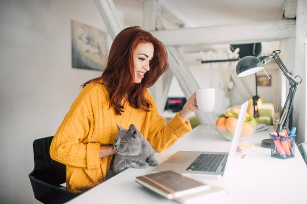istock Girl with a cat in her lap drinking coffee 1128253486