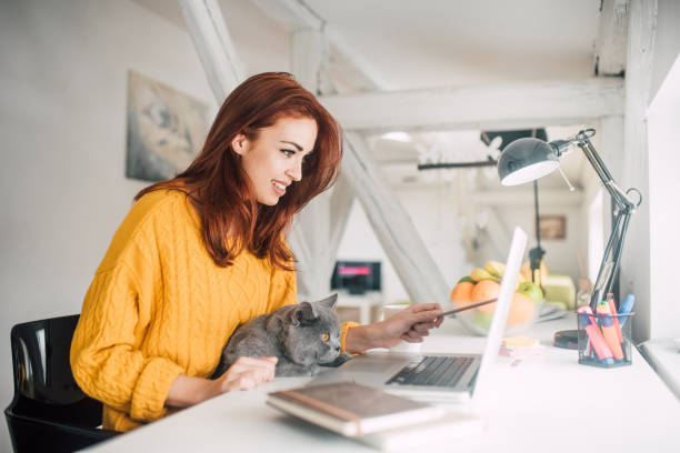 istock Girl and a cat looking at laptop 1128253496