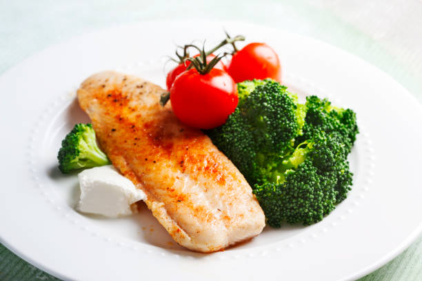 istock Fried Basa Fillet with sauce, broccoli and fresh tomato. 1128255026
