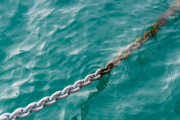 Photo of anchor chain lowered into the sea