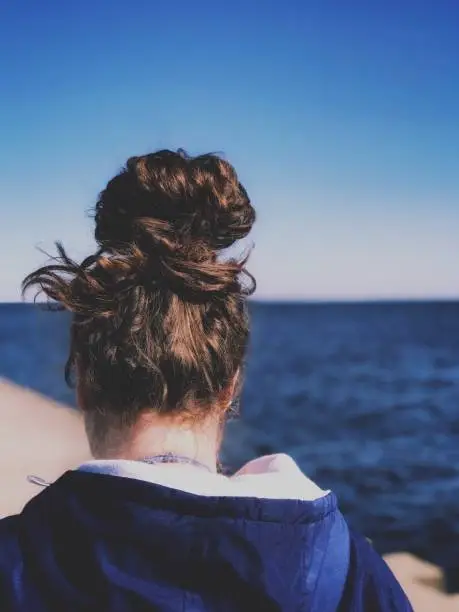 Photo of Giant bun hair on teenager walking down a pier on Lake Michigan in Menominee , Michigan in The Upper Peninsula.