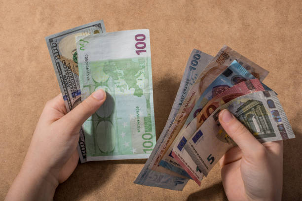 istock Hand holding American dollar  isolated on wooden background 1128259092