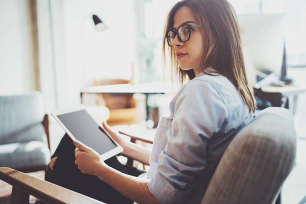 istock Handsome young blonde wearing glasses and using electronic touch tablet computer on sunny workplace.Horizontal. Blurred background. 1128263372