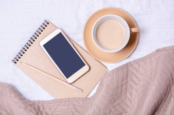 istock Cup of coffee with saucer notepad pencil smartphone 1128264144