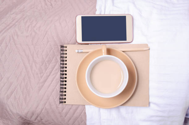istock Cup of coffee with saucer notepad pencil smartphone 1128264162