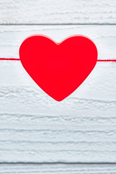 istock A single red heart hanging on a string against white boards 1128272301