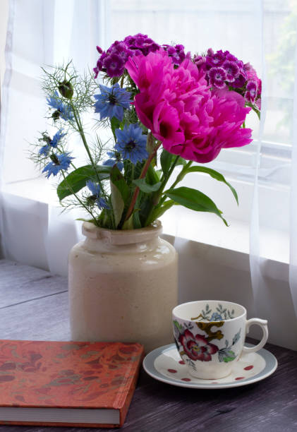 istock Summer flowers in a vase by a window 1128274098