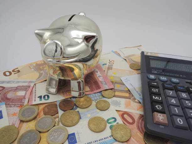 istock Money, piggy bank, and a calculator on a table. 1128275251