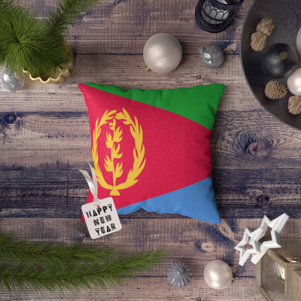 szczęśliwego nowego roku tag z flagą erytrei na poduszce. koncepcja dekoracji bożonarodzeniowej na drewnianym stole z pięknymi przedmiotami. - state of eritrea zdjęcia i obrazy z banku zdjęć