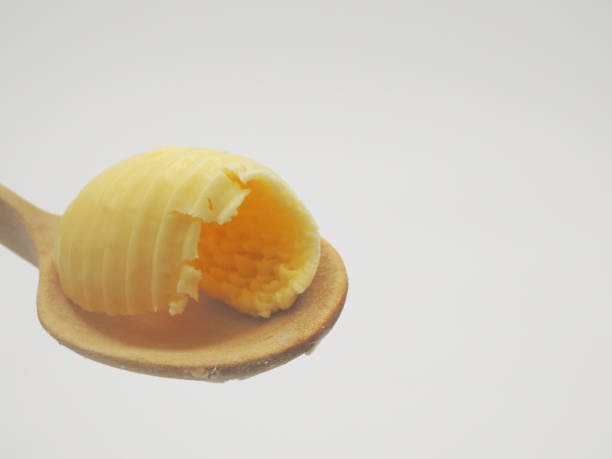 istock roll of butter on a wooden spoon. 1128277210