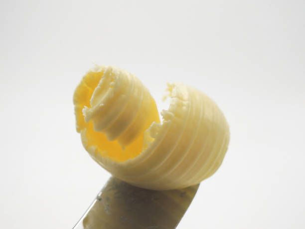 istock roll of butter on a wooden spoon. 1128277219