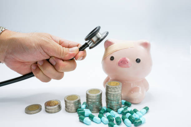istock A piggy bank with a bandage at head being placed stethoscope at head  with stacking coins  and blue green capsules pillon  white background , conceptual for increasing medical expense for sickness 1128280963