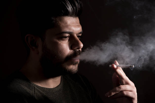 istock portrait of man burning cigarette 1128283520