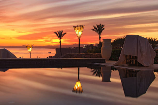 estância turística de luxo tropical. vista deslumbrante da noite do mar vermelho e colorido vibrante céu após o pôr do sol. piscina com vista para o mar vermelho. península do sinai, sharm al-sheikh, egito - tourist resort hotel swimming pool night - fotografias e filmes do acervo