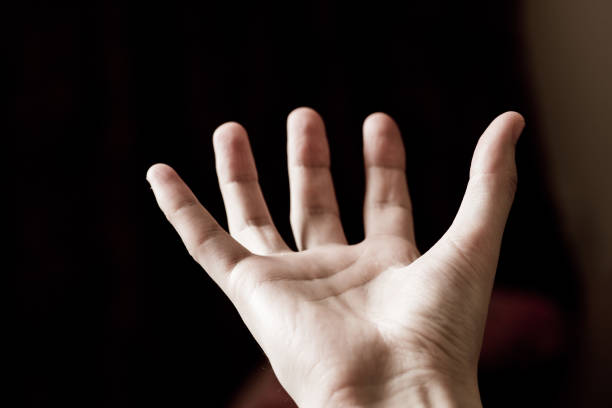istock man's hand on a black background shows something 1128294395