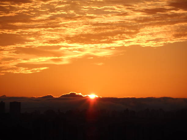 Beautiful image of sunrise behind clouds and, above, golden clouds