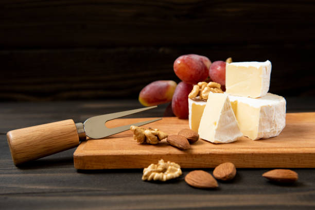 istock Cheese and grapes on a dark background 1128295730