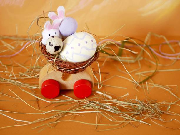 istock Easter decoration, painted egg, toy wooden car on a bright pastel background 1128300265