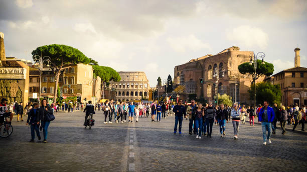 os turistas caminhar via dei fori imperiali com o coliseu, em roma - travel tourist roman forum rome - fotografias e filmes do acervo