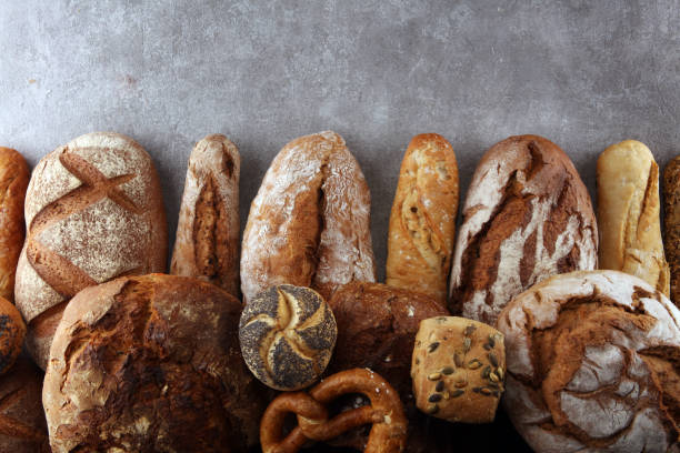 istock Assortment of baked bread and bread rolls on stone table background 1128305405