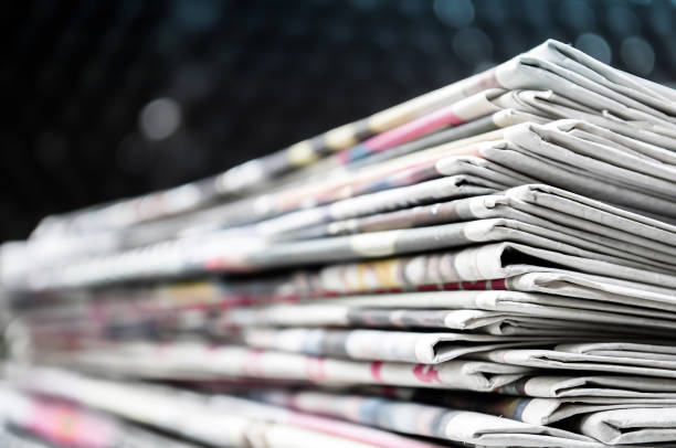 istock Newspapers folded and stacked on the table modern dark background. Closeup newspaper and selective focus image. 1128307539