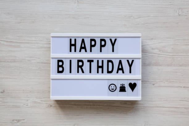 istock Modern board with text 'Happy Birthday' on white wooden background, top view. Flat lay, overhead, from above. 1128309028