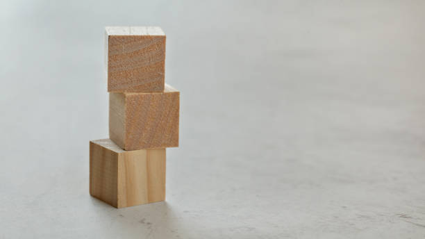 istock Pile with three empty wooden cubes - add your letters, on white board, space for text on right. 1128310078
