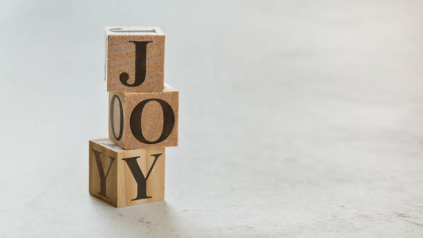 istock Pile with three wooden cubes - letters JOY on them, space for more text / images on right side. 1128310206