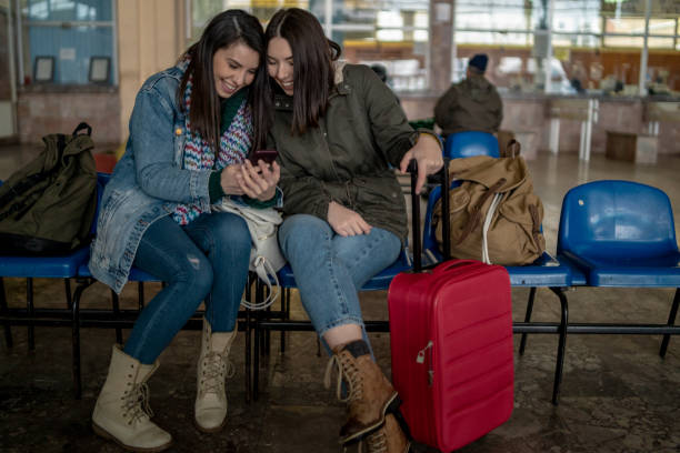 istock Two friends talking and waiting train in railway station 1128317032