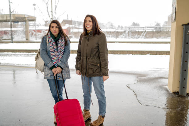 istock Two friends talking and waiting train in railway station 1128317107