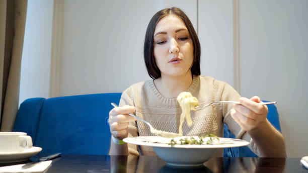 istock young woman in a cafe with an appetite eating a pasta. 1128317387