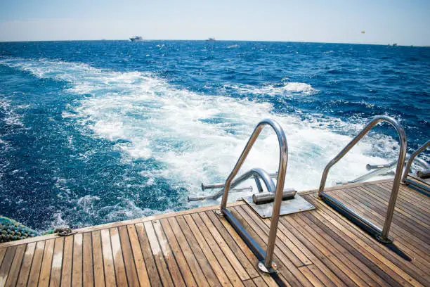 view of the yacht's gangway against the azure sea. relax. swimming. wooden deck and gangway